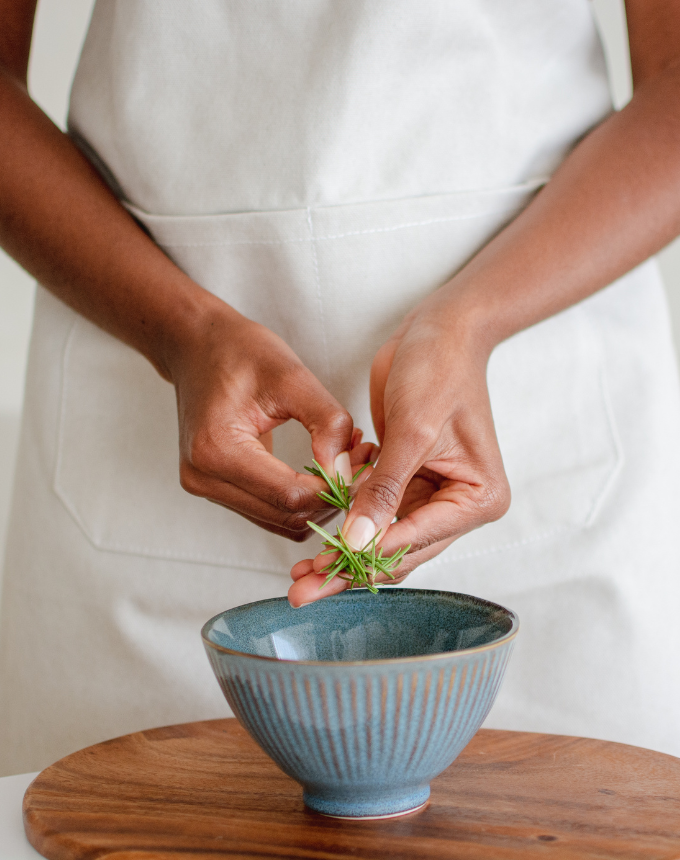WSHC Cincinnati gut health woman preparing herbs into a bowl